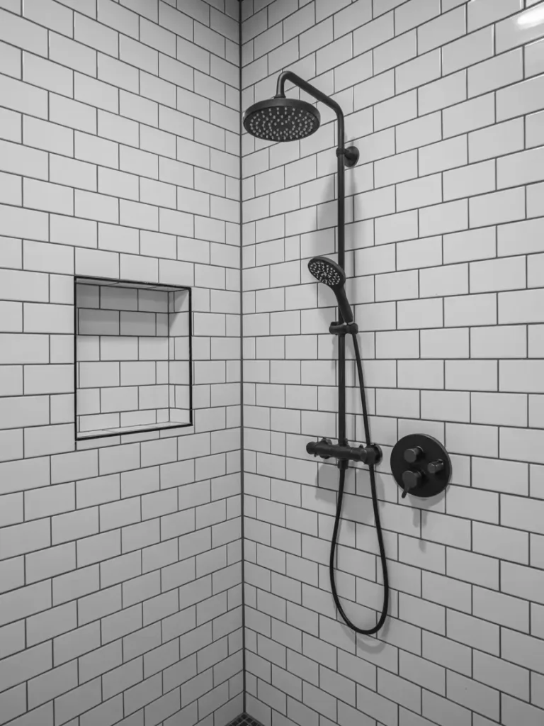 Black shower fixtures with modern matte finish against white subway tile walls in a contemporary bathroom.