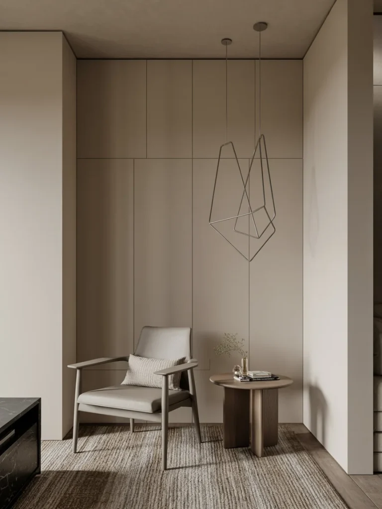 Minimalist modern living room nook with sleek armchair, round side table, and geometric pendant light.