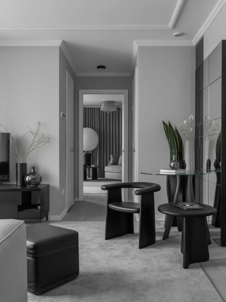 Small modern black and grey living room with minimalist furniture and sleek monochrome design.